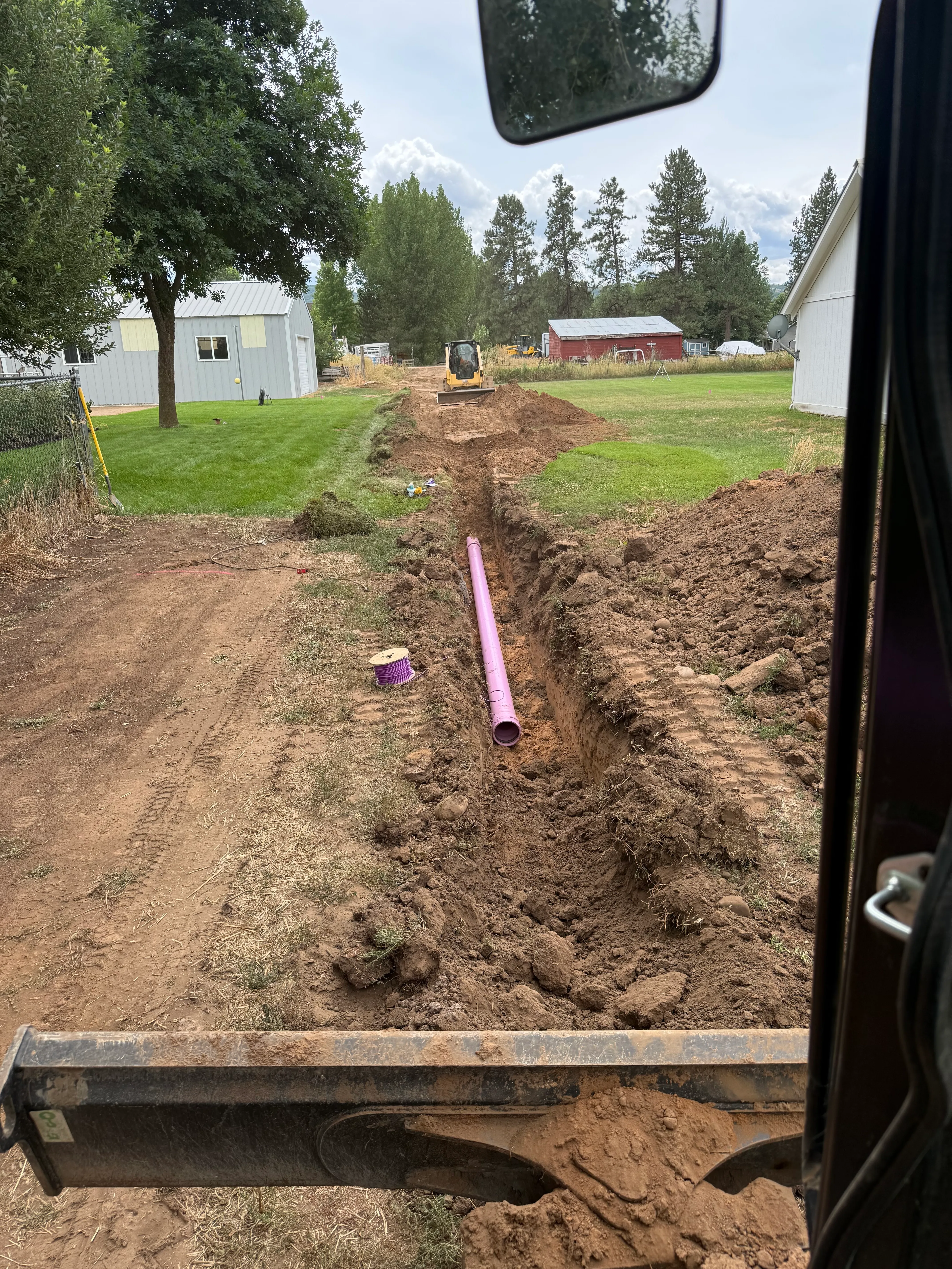 AccuRite Excavation crew installing secondary irrigation water line using purple PVC pipe in Northern Utah