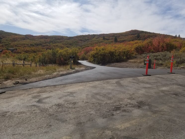 AccuRite Excavation actively engaged in road construction, showcasing their comprehensive process from tree removal to subgrade cutting, pipe and drainage installation, and sub-base preparation, under their E100 license.