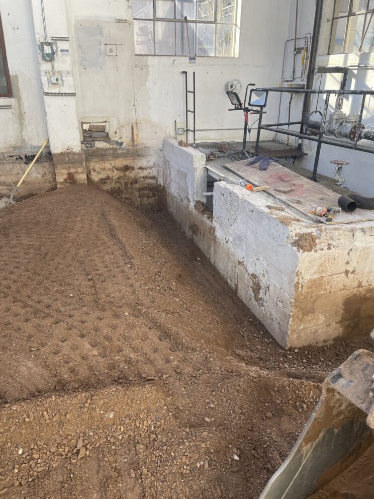 AccuRite Excavation conducting soil excavation and shaping for drainage channels under an existing building at Hill Air Force Base, emphasizing their structural expertise.